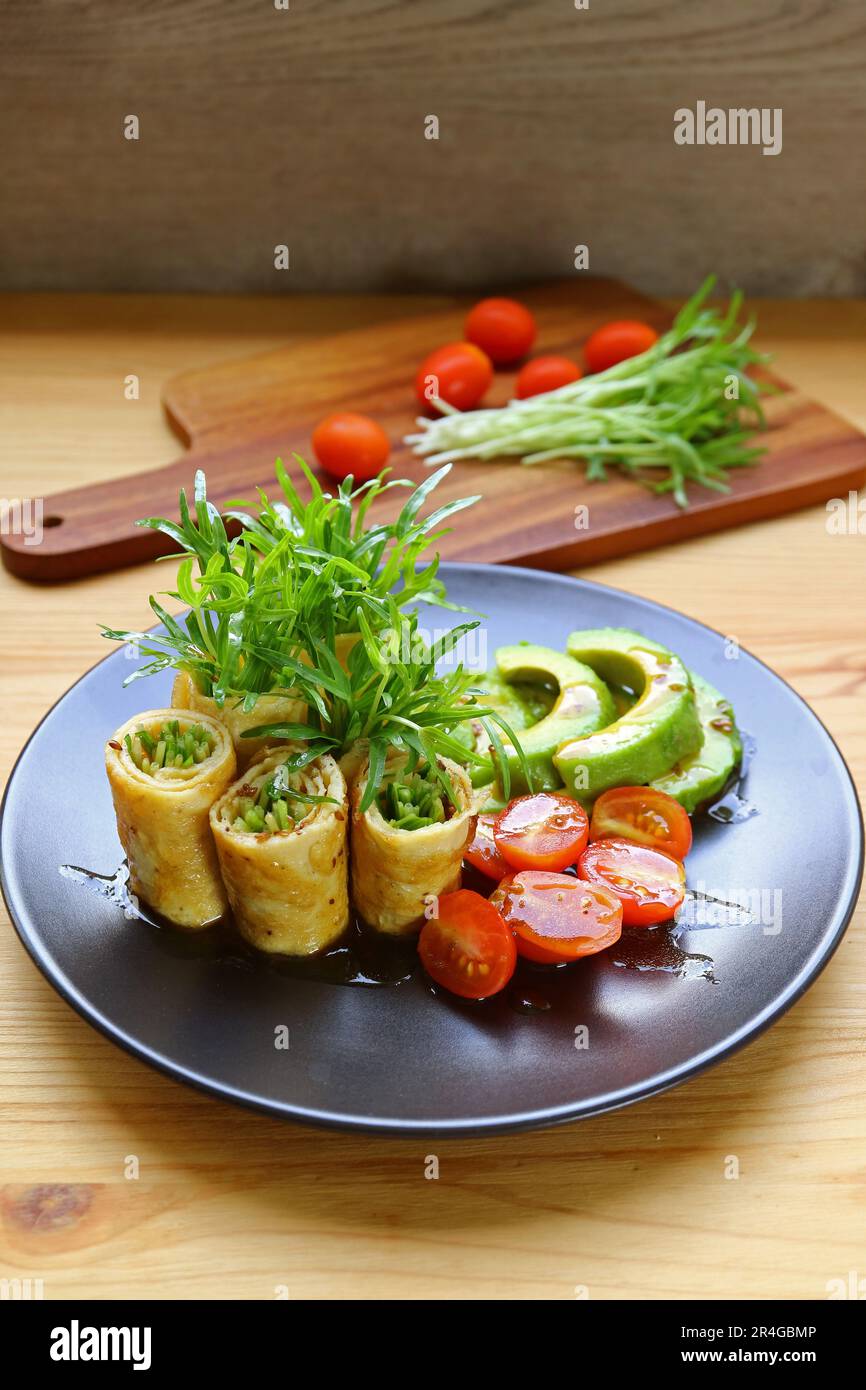 Assiette de délicieux petits pains aux œufs avec des microverts d'épinards d'eau douce, de l'avocat et de la salade de tomates Banque D'Images