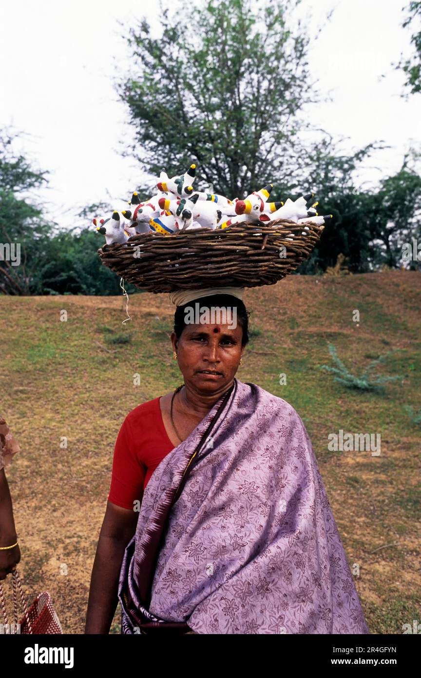Une femme qui vend des poupées en terre cuite à la tête pendant le festival Ayyanar, Tamil Nadu, Inde, Asie Banque D'Images