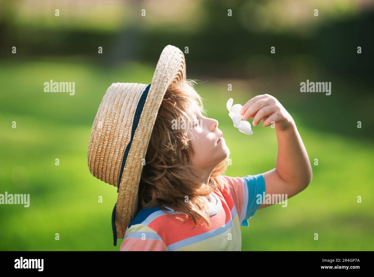 Gros plan d'un petit enfant mignon dans un chapeau de paille sentant la  fleur de la plumeria. Concept d'enfance et de parentalité. Vacances d'été  Photo Stock - Alamy