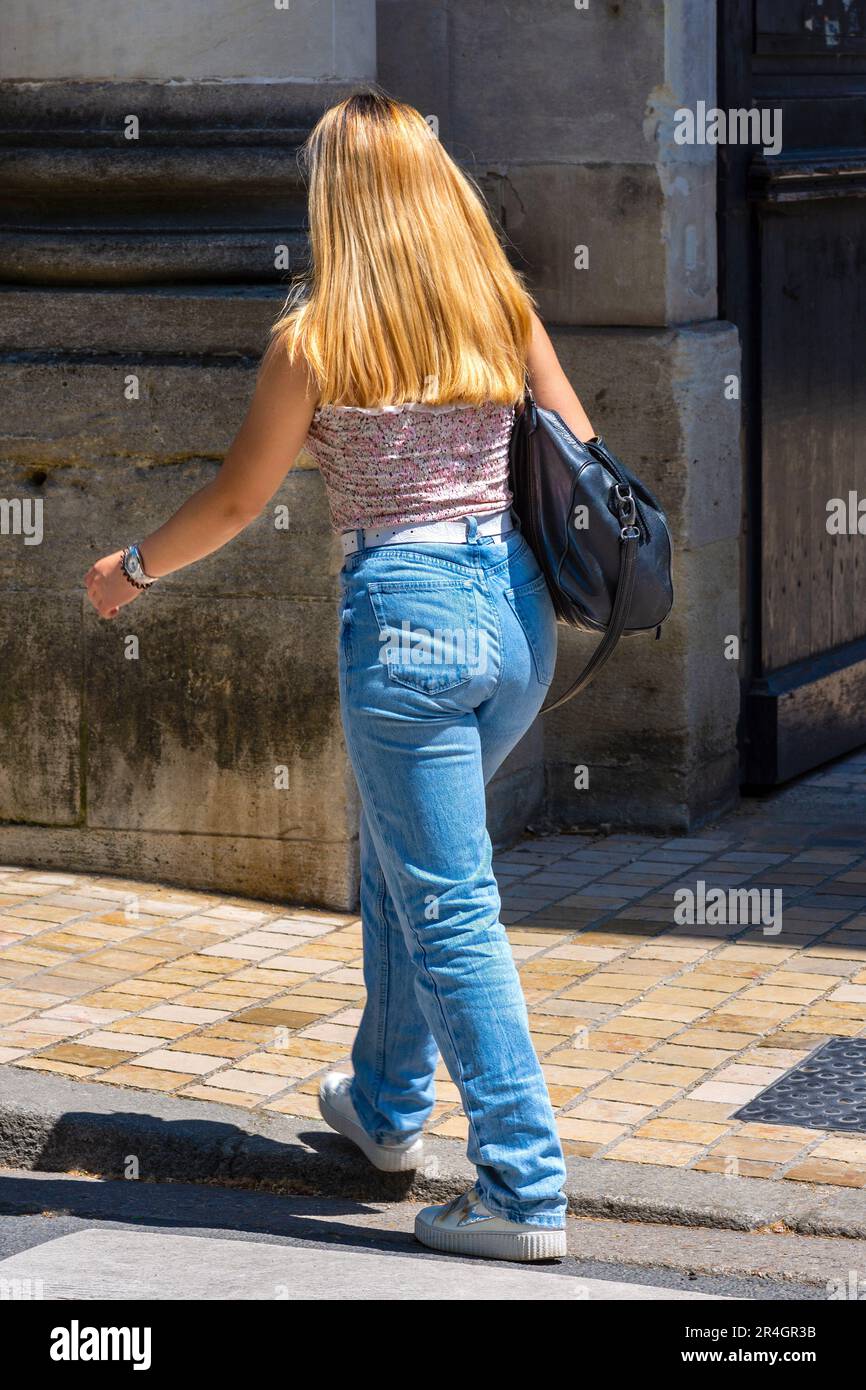 Adolescent blond en Jean marchant dans la rue - Tours, Indre-et-Loire (37), France. Banque D'Images