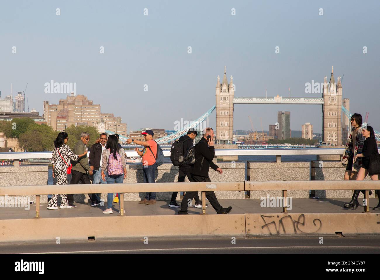 Touristes et navetteurs sur le London Bridge avec Tower Bridge en arrière-plan Banque D'Images