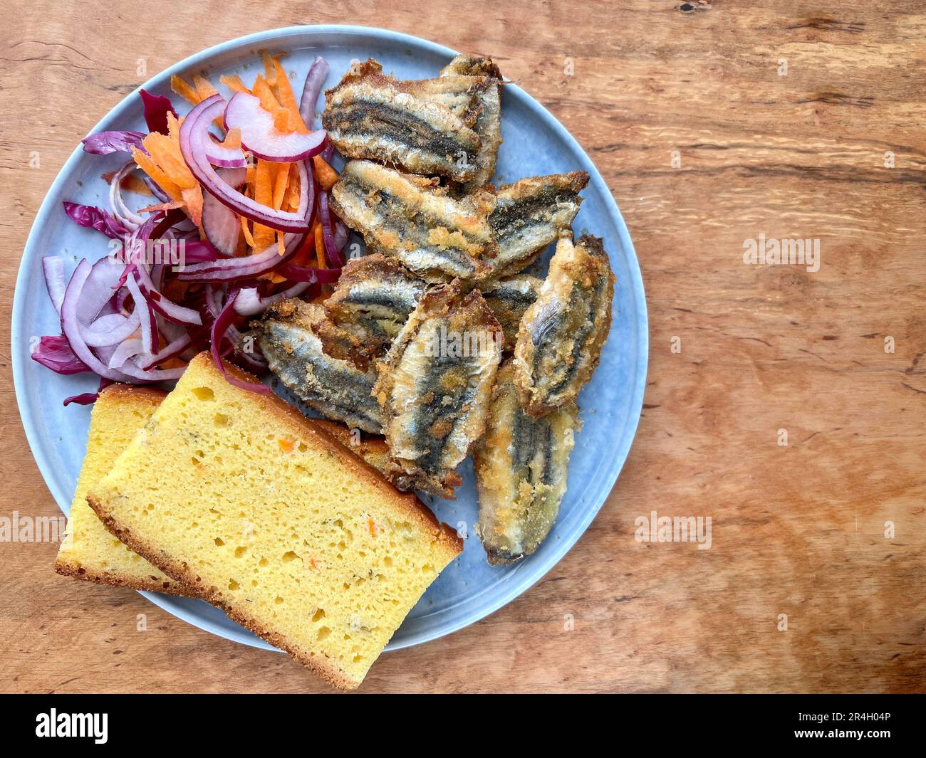 poisson frit, vue de dessus délicieux poisson frite d'anchois et pain de maïs sur la table servi avec une salade fraîche. belle photo de concept de fruits de mer avec espace de copie. trad Banque D'Images