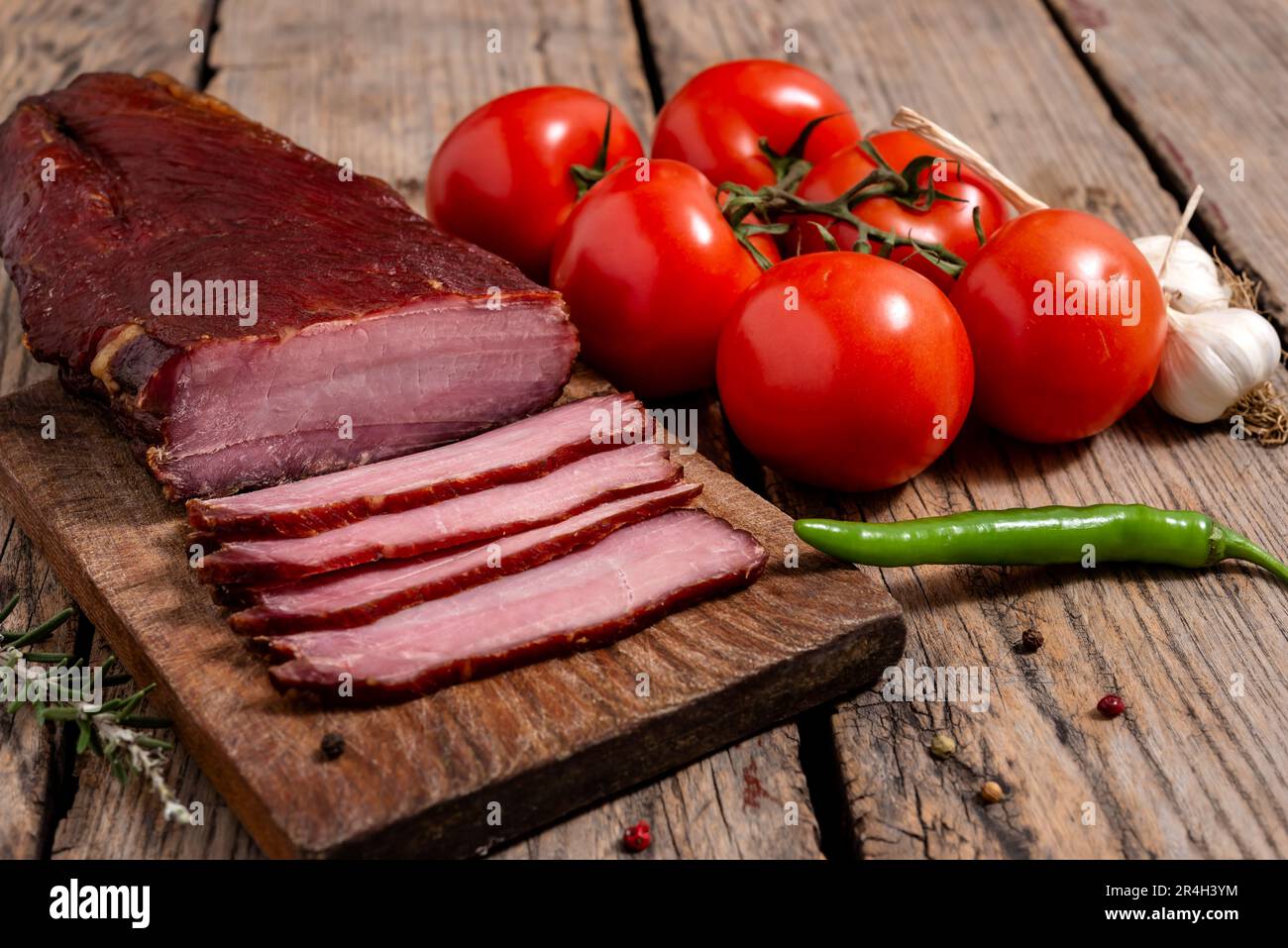 Planche à découper avec de la viande séchée, des légumes et des épices sur une table en bois. Mise au point sélective. Banque D'Images