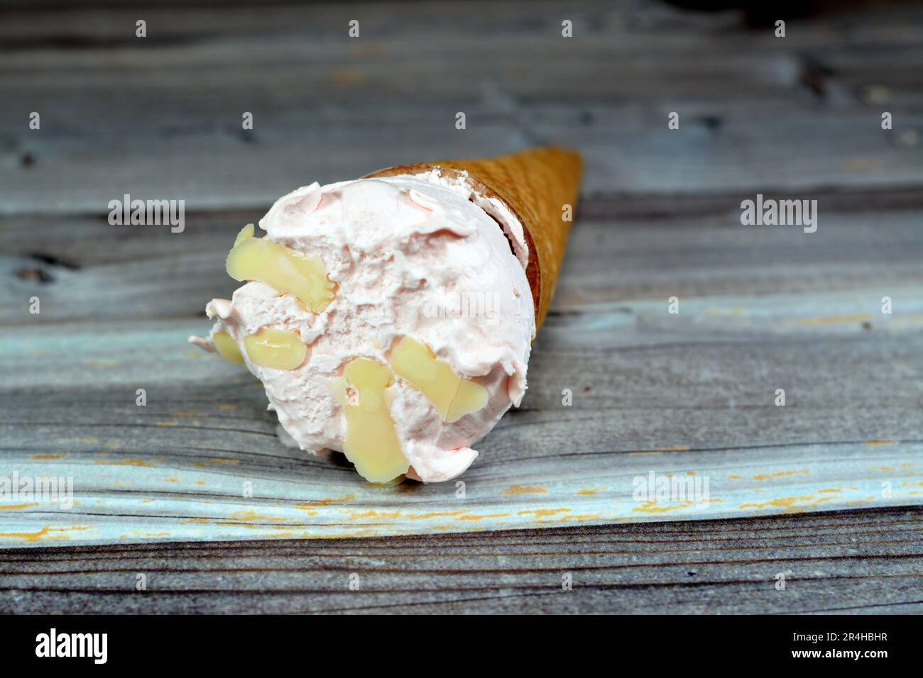 Crème glacée aux saveurs spéciales dans des cônes de cachets croustillants, la glace froide se mélange dans des biscuits de cachets isolés sur fond de bois, l'été et les vacances Banque D'Images