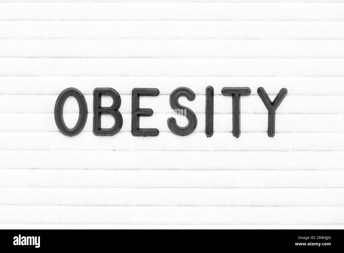 Lettre de couleur noire dans le mot obésité sur fond de tableau de feutre blanc Banque D'Images