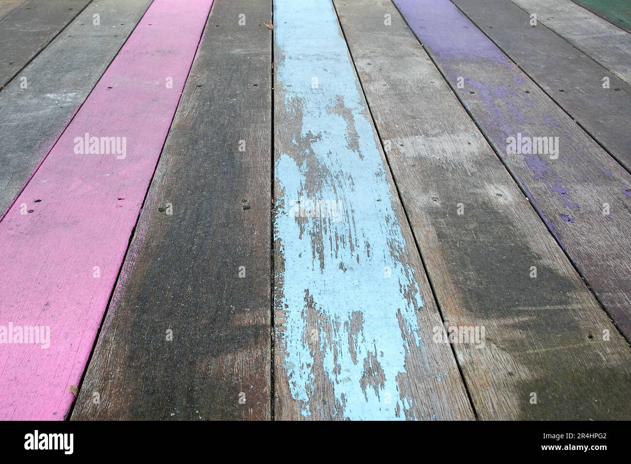 Peinture violet pâle, rose et aqua sur le pont en bois abîmé Banque D'Images
