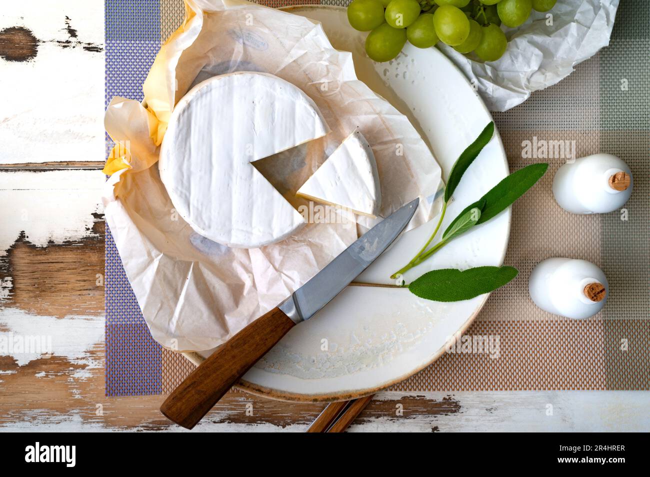 Fromage Camembert sur l'assiette avec des raisins et des herbes Banque D'Images