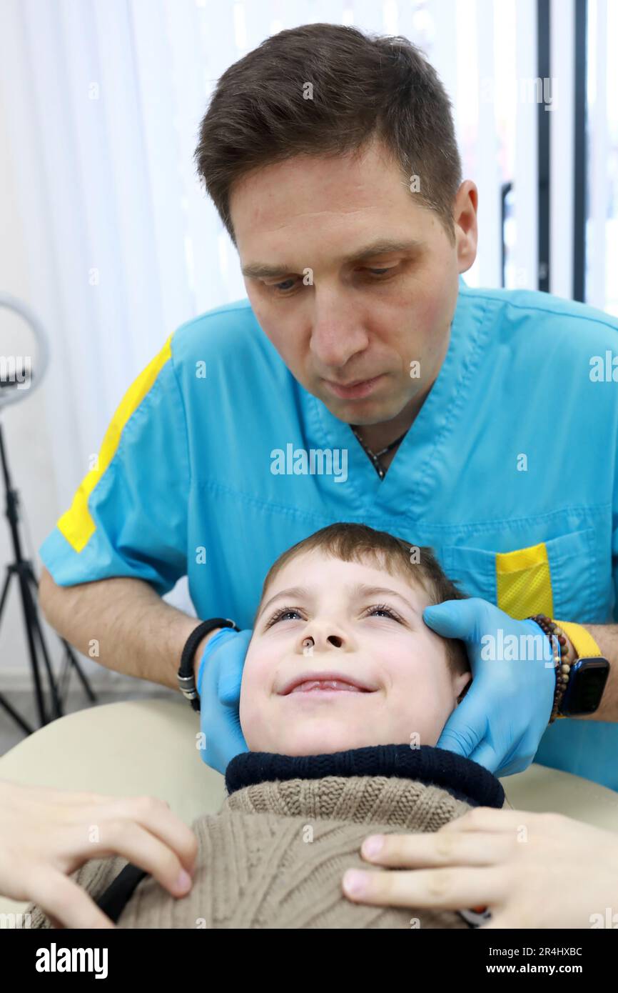 L'ostéopathe traite les organes respiratoires du garçon en clinique Banque D'Images