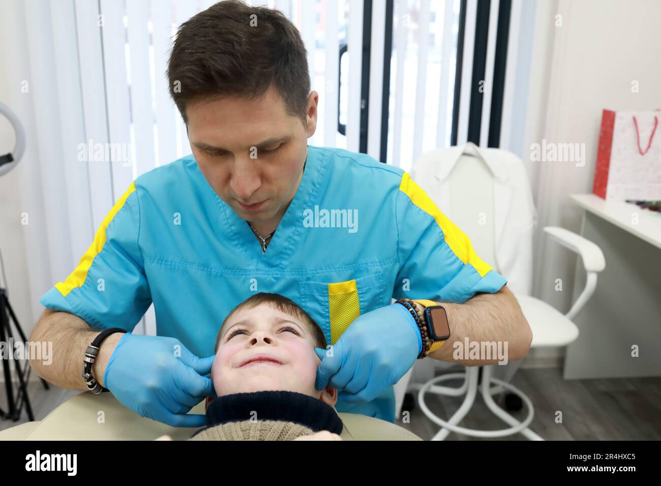 L'ostéopathe traite le système respiratoire du garçon sur le canapé en clinique Banque D'Images