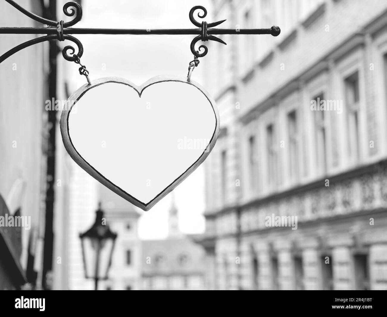 Coeur, noir et blanc vierge ou forme de coeur vide pendu sur la rue avec une vue floue sur la ville et la rue en Europe. destination de voyage arrière-plan ou surfa Banque D'Images