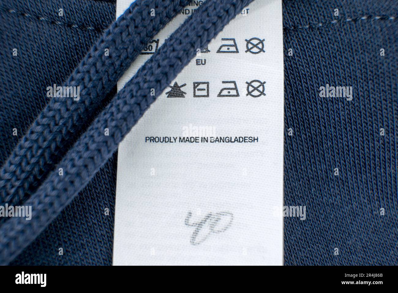 Vêtements de sport bleu foncé avec étiquette blanche « FIÈREMENT FABRIQUÉS AU BANGLADESH ». Banque D'Images