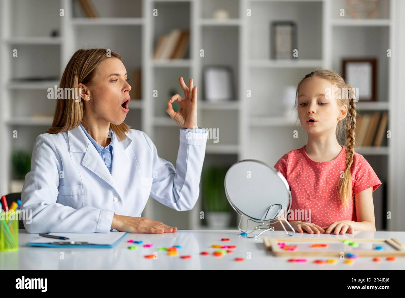 Concept de traitement de la parole. Mignon petite fille prononçant son O  regardant le miroir Photo Stock - Alamy