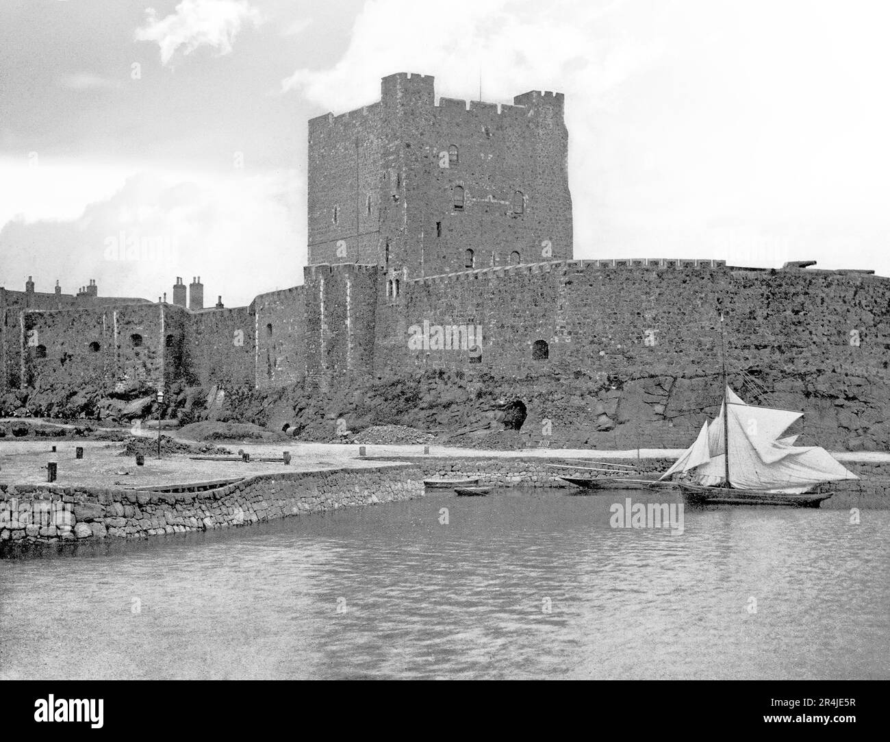 Vue de la fin du 19th siècle sur le château de Carrickfergus, un château normand en Irlande du Nord, situé dans la ville de Carrickfergus dans le comté d'Antrim, sur la rive nord de Belfast Lough. Assiégé à son tour par les écossais, irlandais, anglais et français, le château a joué un rôle militaire important étant stratégiquement utile, avec 3/4 du périmètre du château entouré d'eau. Banque D'Images