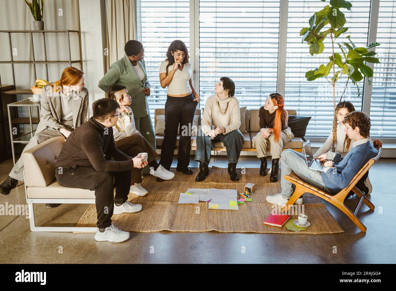 Des collègues multiraciaux, hommes et femmes, discutent lors d'une réunion au bureau de création Banque D'Images