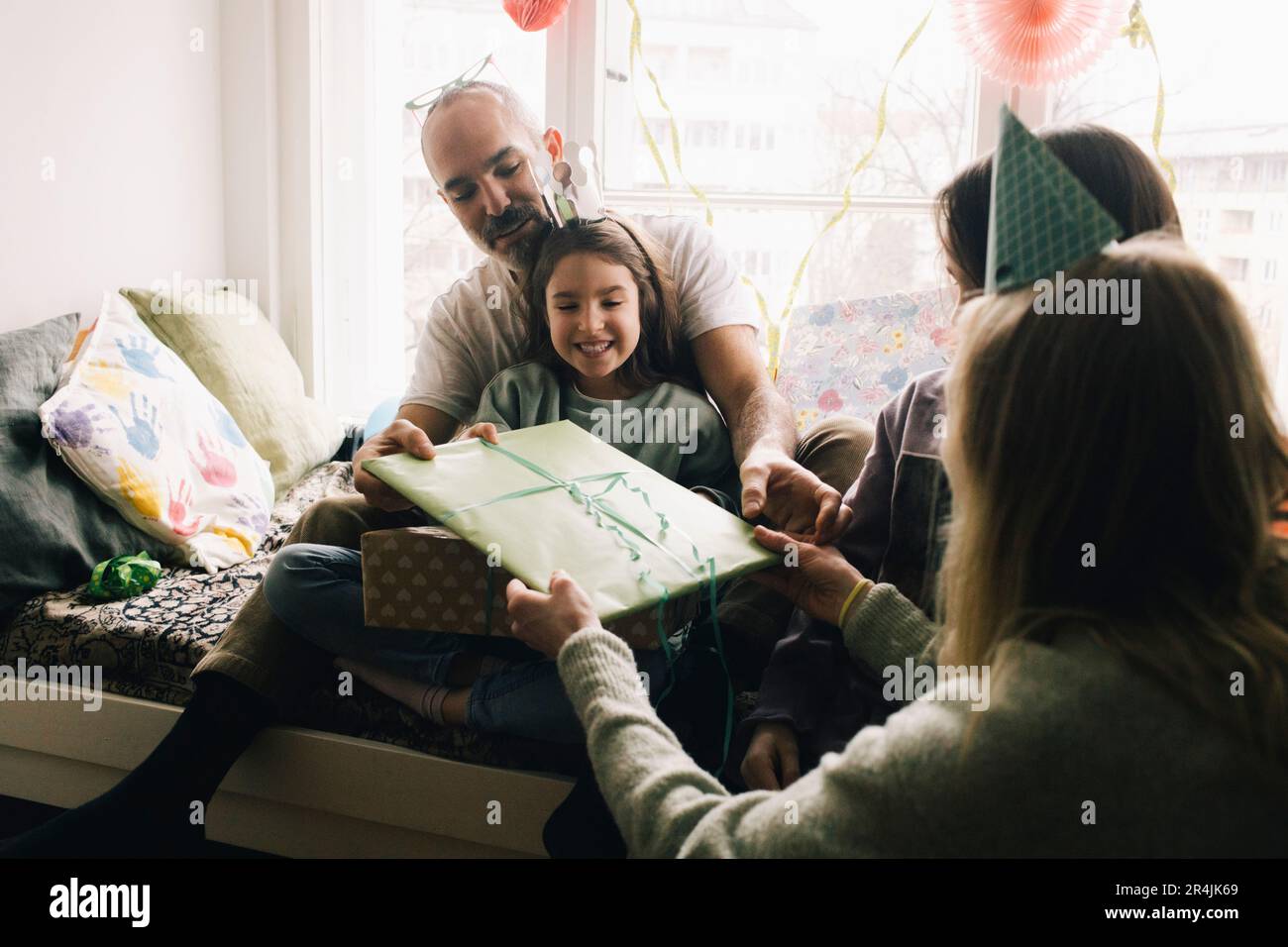 Les parents donnent un cadeau à la fille d'anniversaire à la maison Banque D'Images