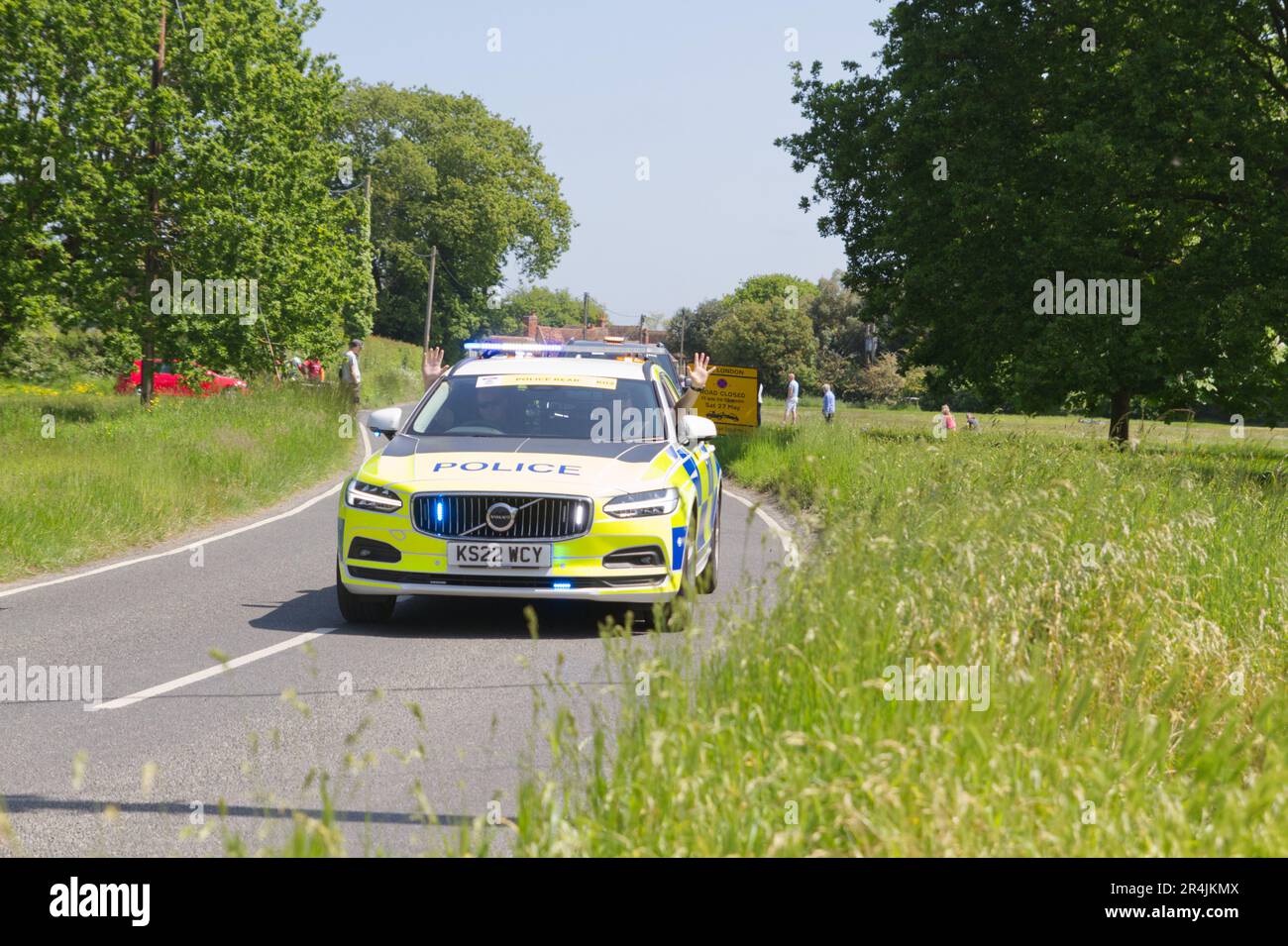 RideLondon Classique 2023 étape 2 traverse le village de Layer-de-la-Haye près de Colchester dans l'Essex. Une voiture de police avec des policiers qui agaient Banque D'Images