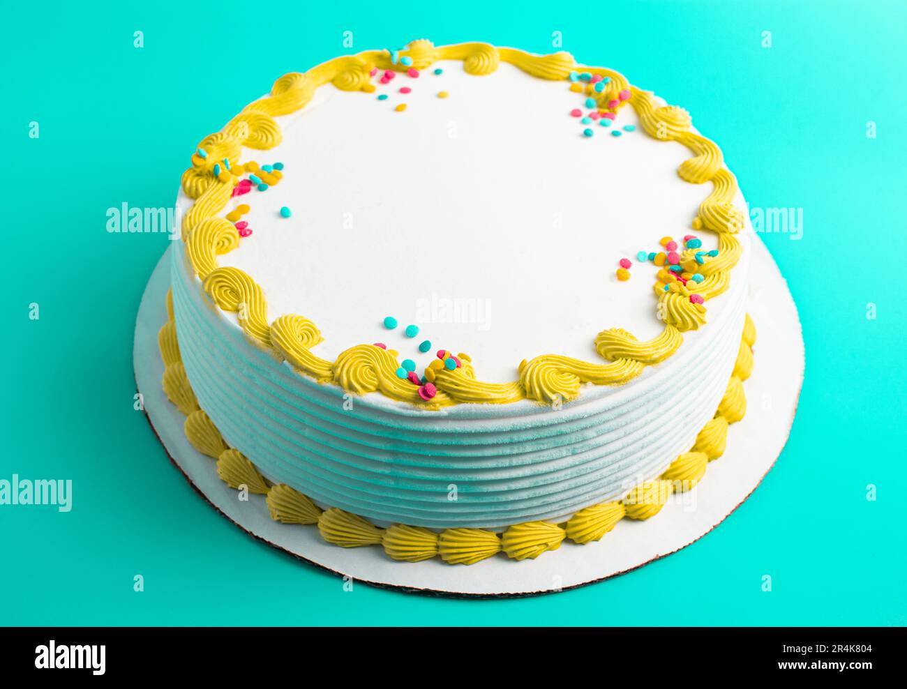 Un gâteau circulaire à la crème glacée blanche avec bordure colorée et prprinkles Banque D'Images