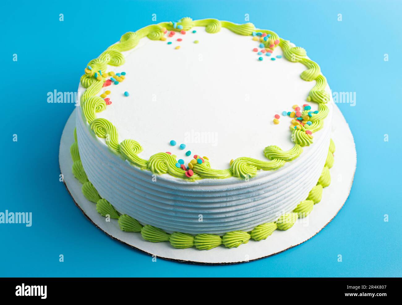 Un gâteau circulaire à la crème glacée blanche avec bordure colorée et prprinkles Banque D'Images