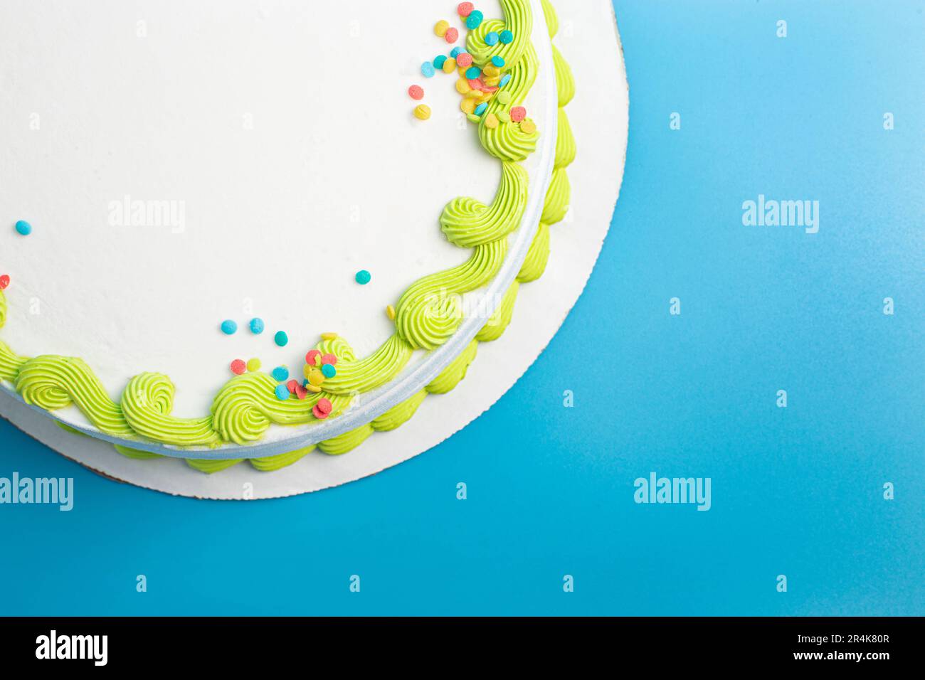 Un gâteau circulaire à la crème glacée blanche avec bordure colorée et prprinkles Banque D'Images