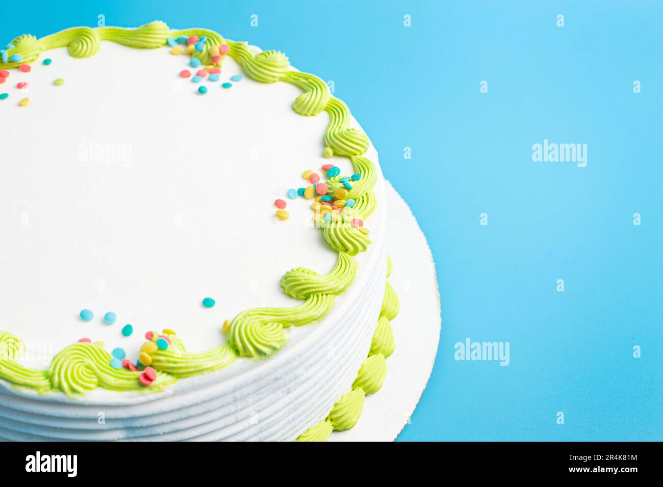 Un gâteau circulaire à la crème glacée blanche avec bordure colorée et prprinkles Banque D'Images