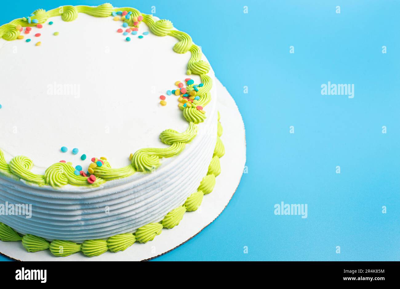 Un gâteau circulaire à la crème glacée blanche avec bordure colorée et prprinkles Banque D'Images