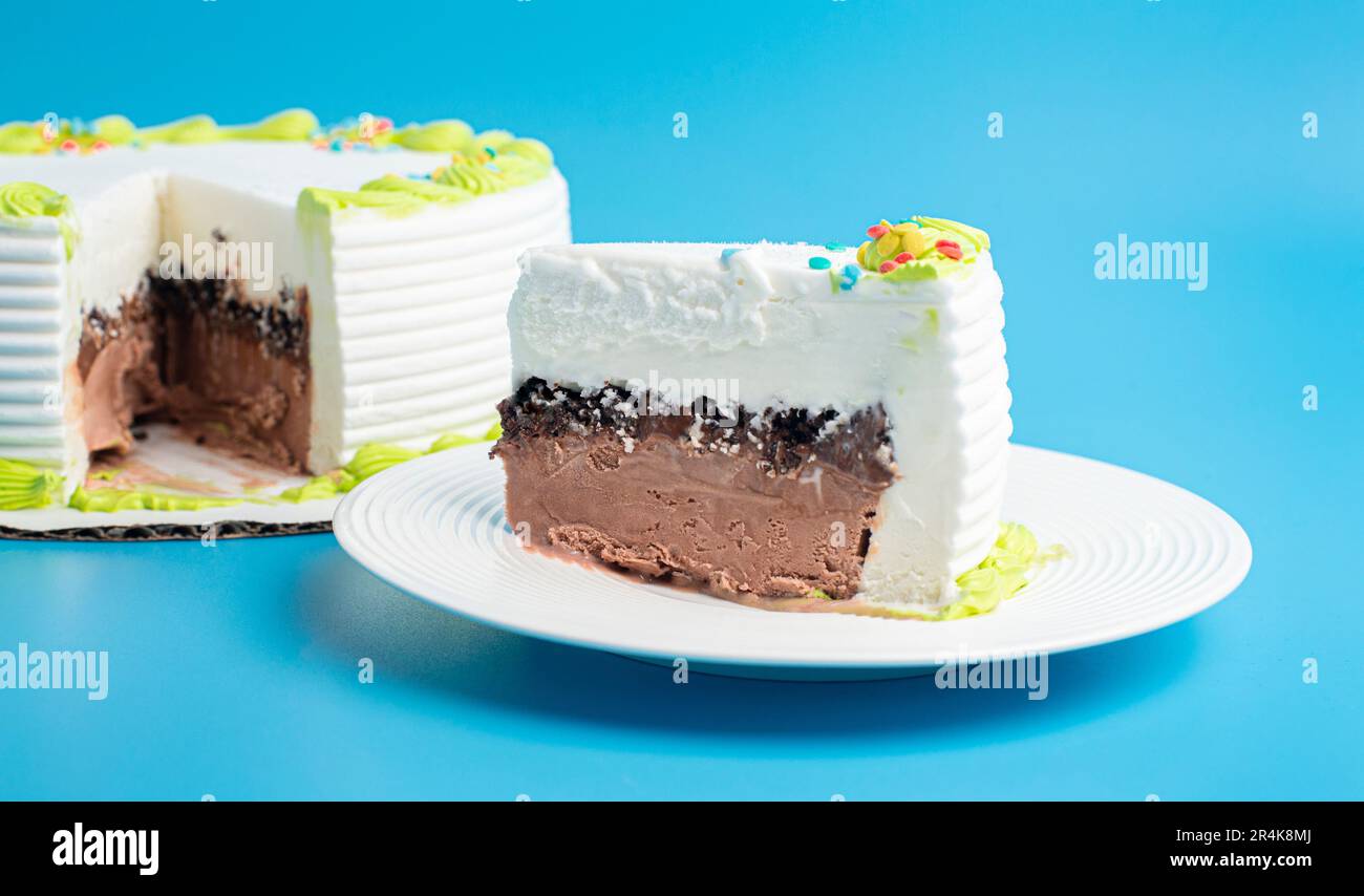 Une tranche de gâteau glace à la vanille et au chocolat sur fond bleu Banque D'Images