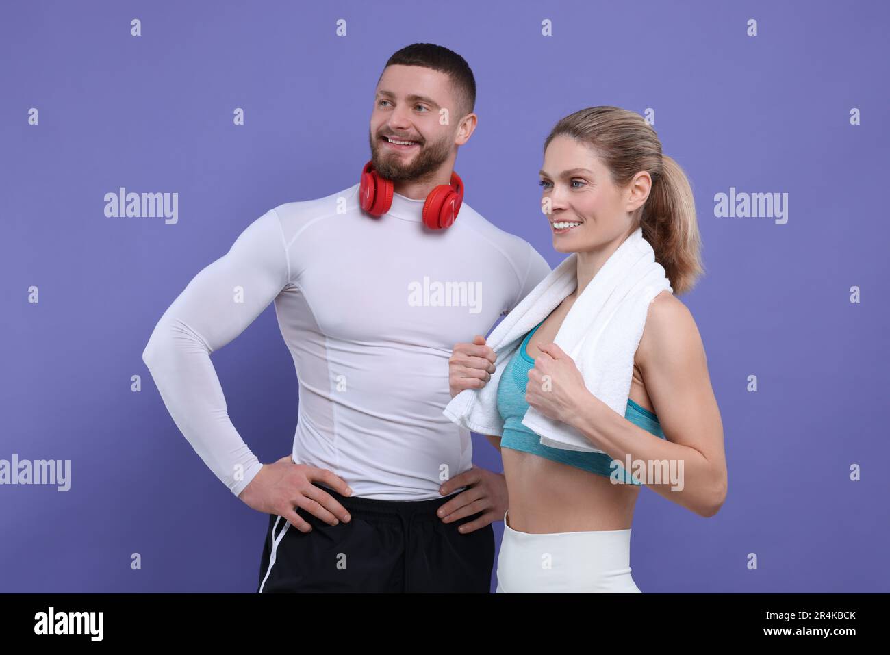 Des sportifs avec un casque et une serviette sur fond violet Banque D'Images
