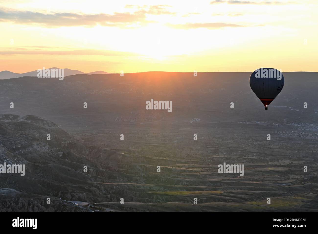 Un ballon d'air chaud silhoueté contre le lever du soleil au-dessus de Capadoccia. Banque D'Images