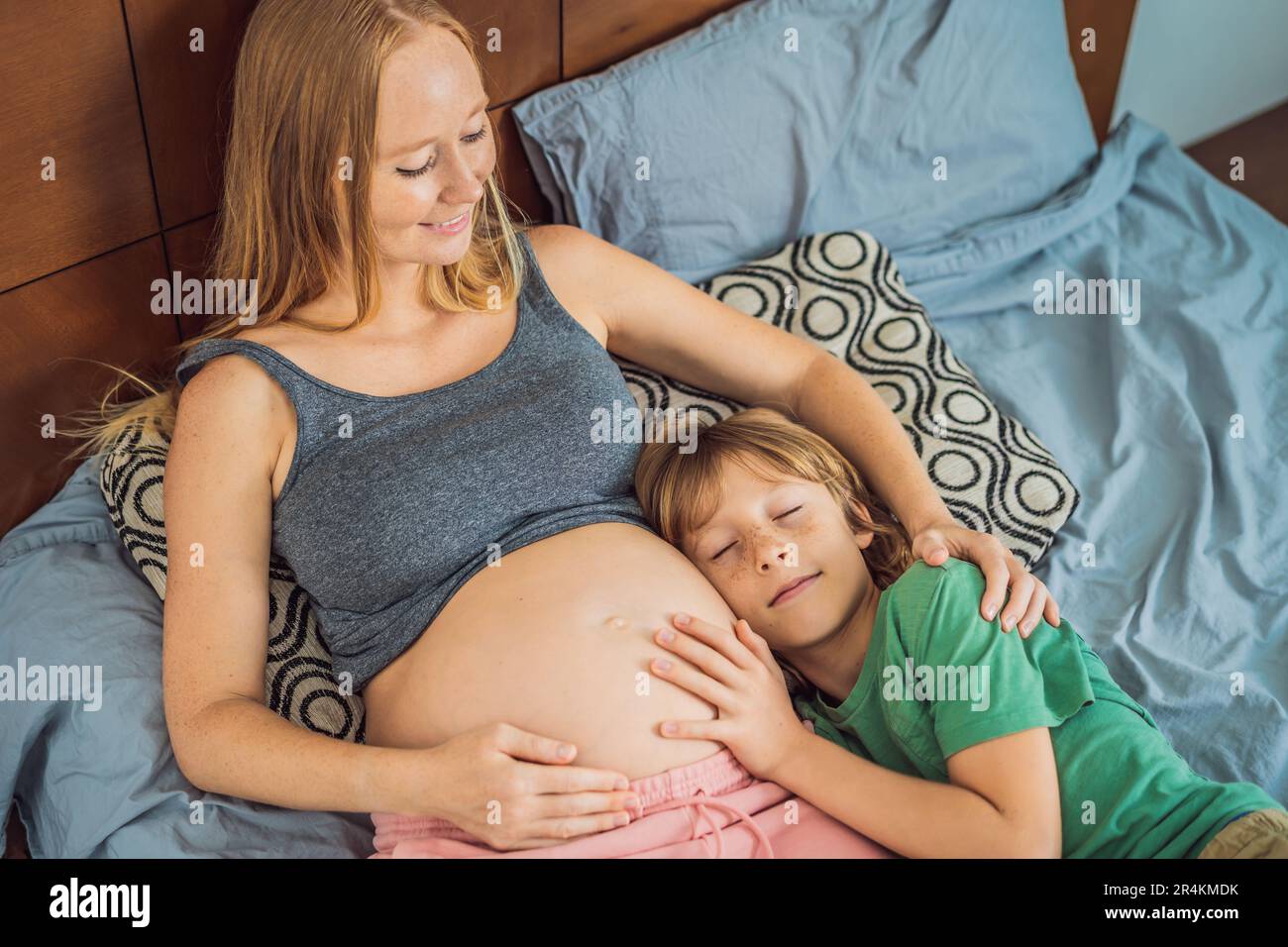 Jeune belle femme enceinte et fils aîné. Le mignon garçon pencha son oreille  contre le ventre de sa mère. S'attendre à un bébé dans le concept de  famille Photo Stock - Alamy