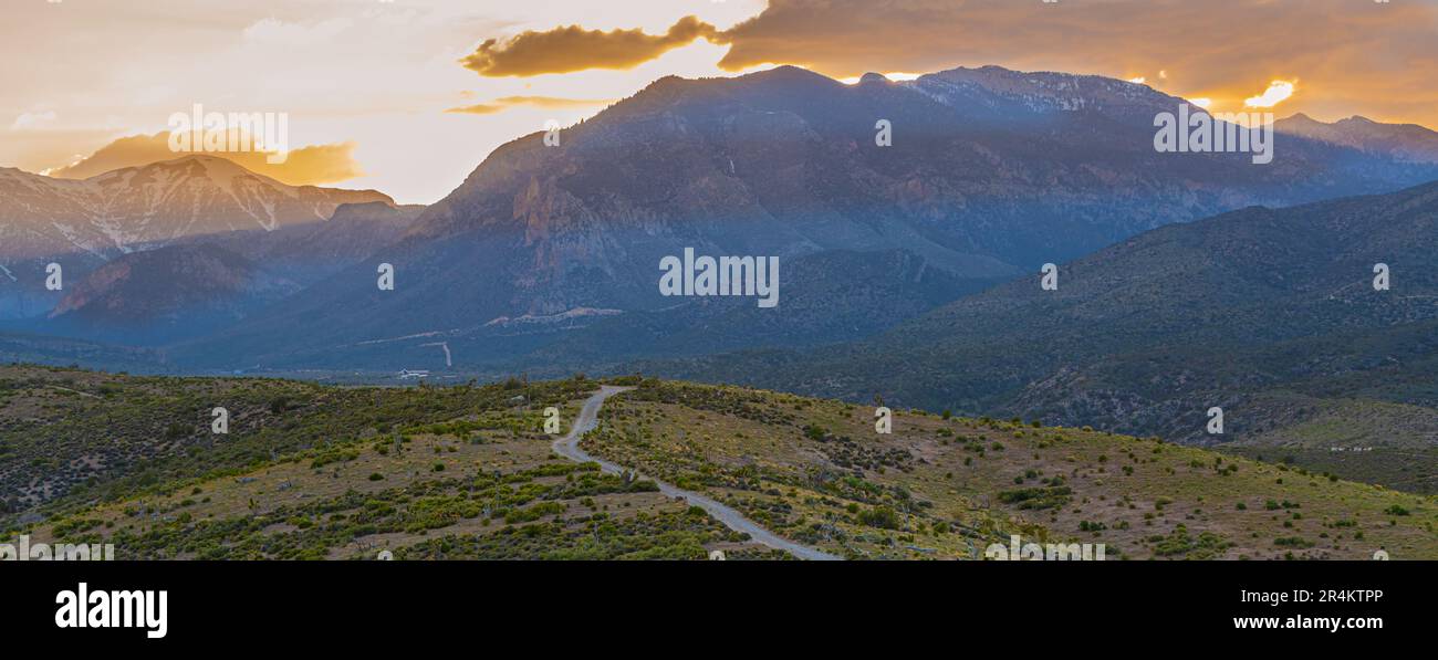 Route de terre menant au coucher du soleil sur la chaîne des montagnes de Spring, zone de loisirs nationale des montagnes de Spring, Nevada, États-Unis Banque D'Images