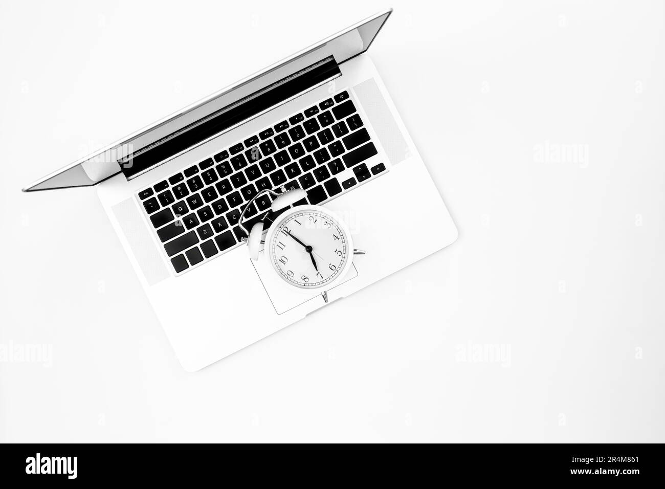 Réveil et ordinateur portable sur fond blanc, vue de dessus. Banque D'Images