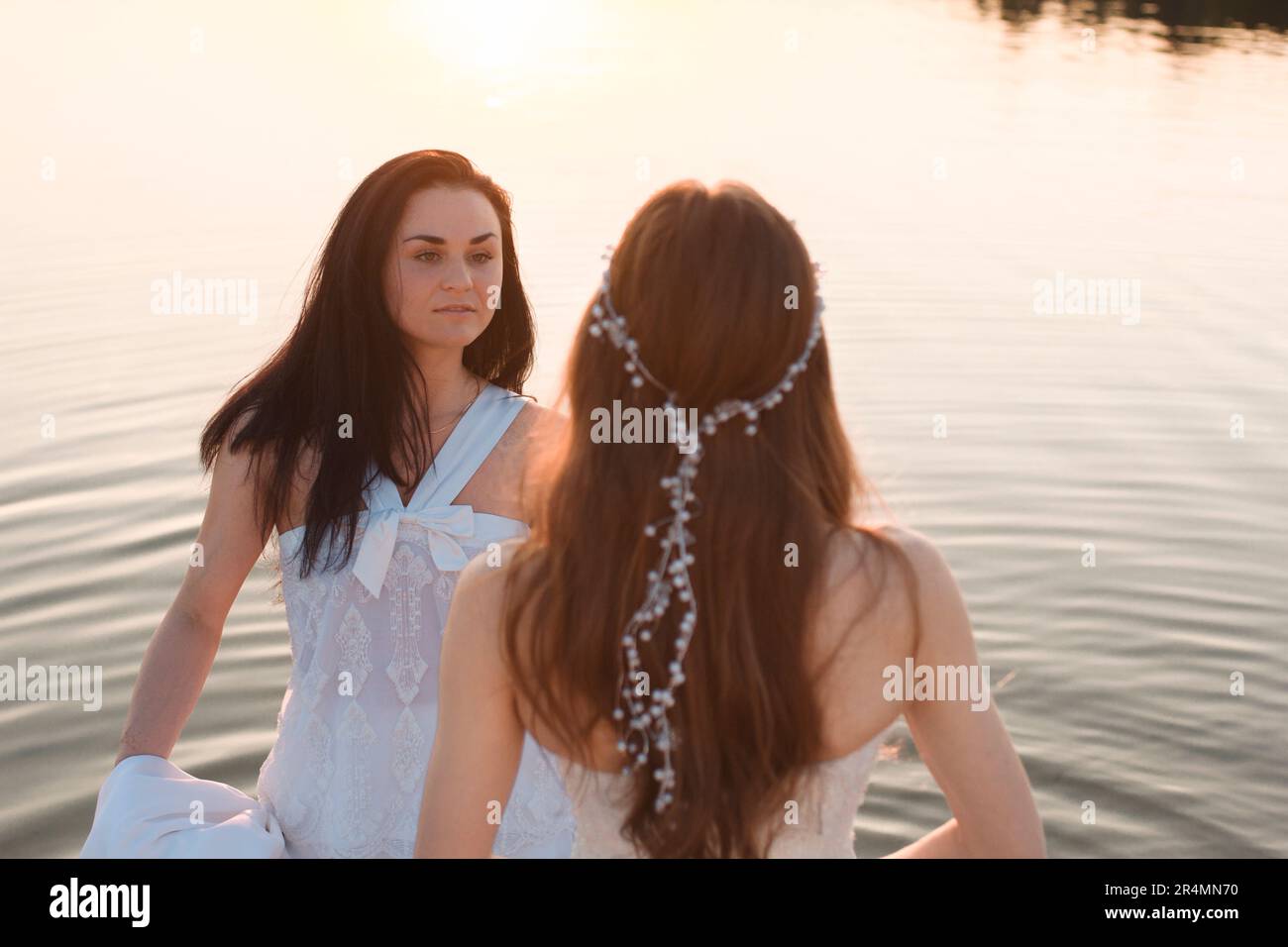 filles dans des robes blanches dans l'eau Banque D'Images