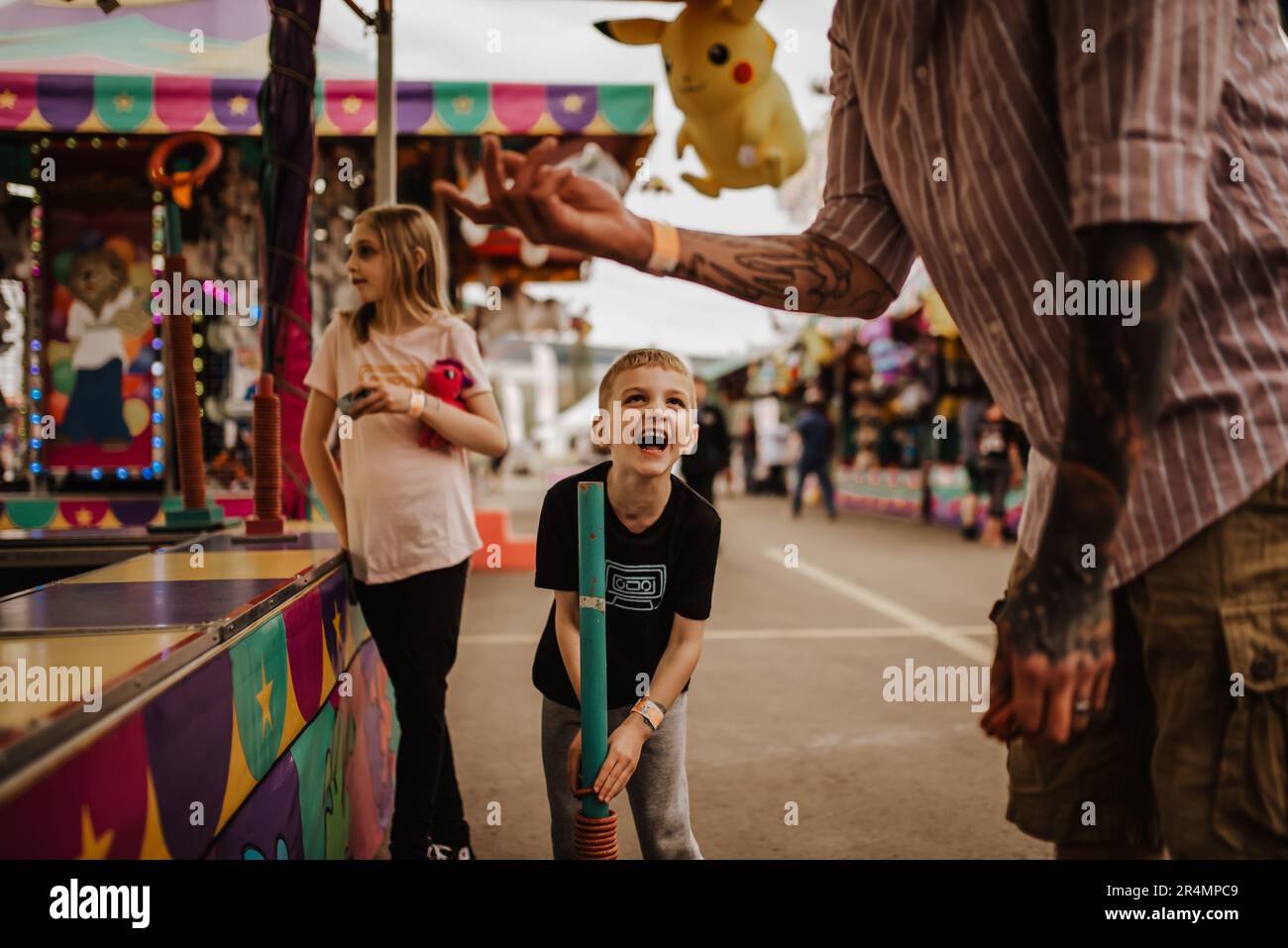 AMUSEZ-VOUS EN FAMILLE AU CARNIVAL EN JOUANT AU JEU DE BAGUE Banque D'Images