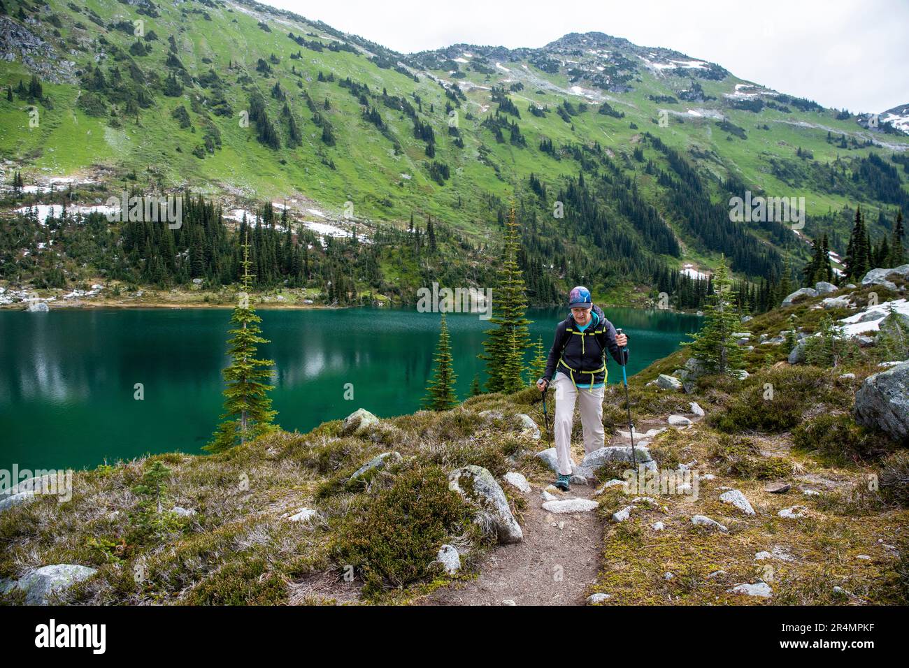 Vue panoramique sur les femmes qui font de la randonnée au bord d'un lac alpin au Canada. Banque D'Images