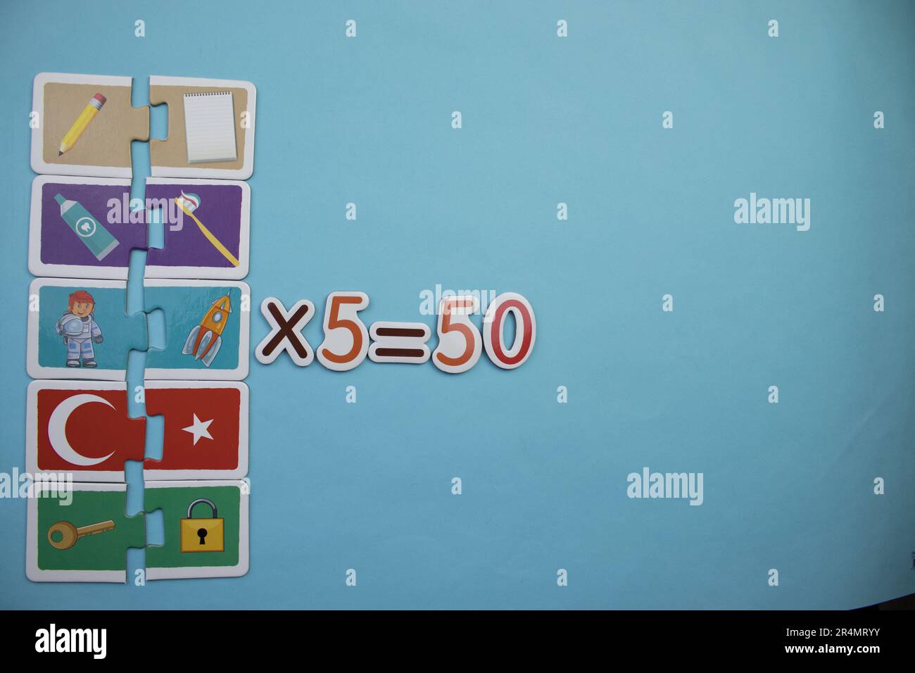 Dix puzzles fois cinq égale cinquante, photographiés d'en haut, placés sur un fond bleu. Banque D'Images
