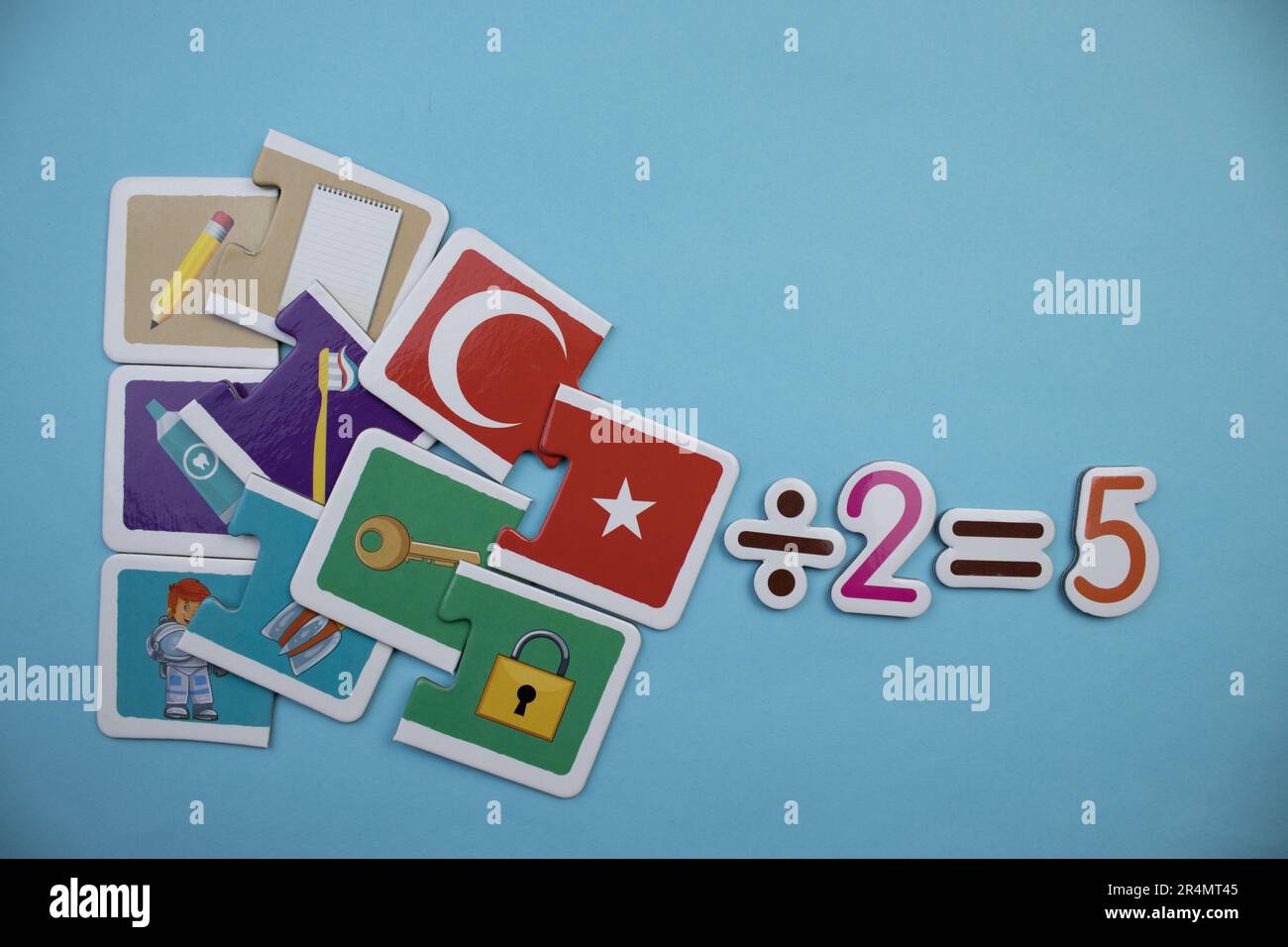 Puzzle puzzles et la division deux égale cinq, photographié d'en haut, placé sur un fond bleu. Banque D'Images