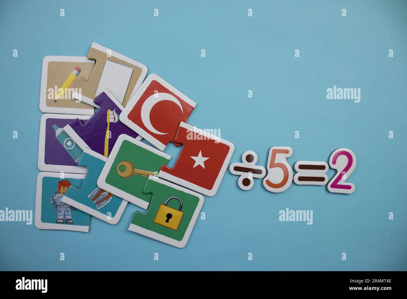 Puzzles et cinq divisés par cinq égaux deux, photographiés d'en haut, placés sur un fond bleu Banque D'Images