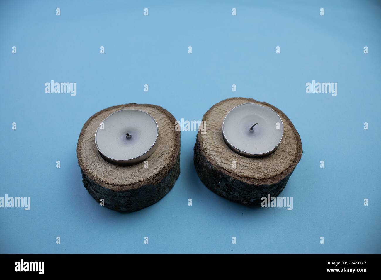 Petites billes et bougies à l'intérieur, photographiées par le dessus, placées horizontalement sur un fond bleu. Banque D'Images