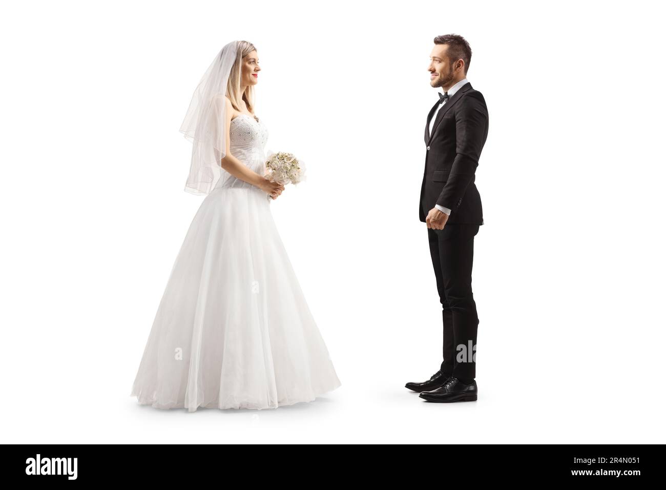 Photo de profil pleine longueur d'une mariée regardant un marié isolé sur fond blanc Banque D'Images