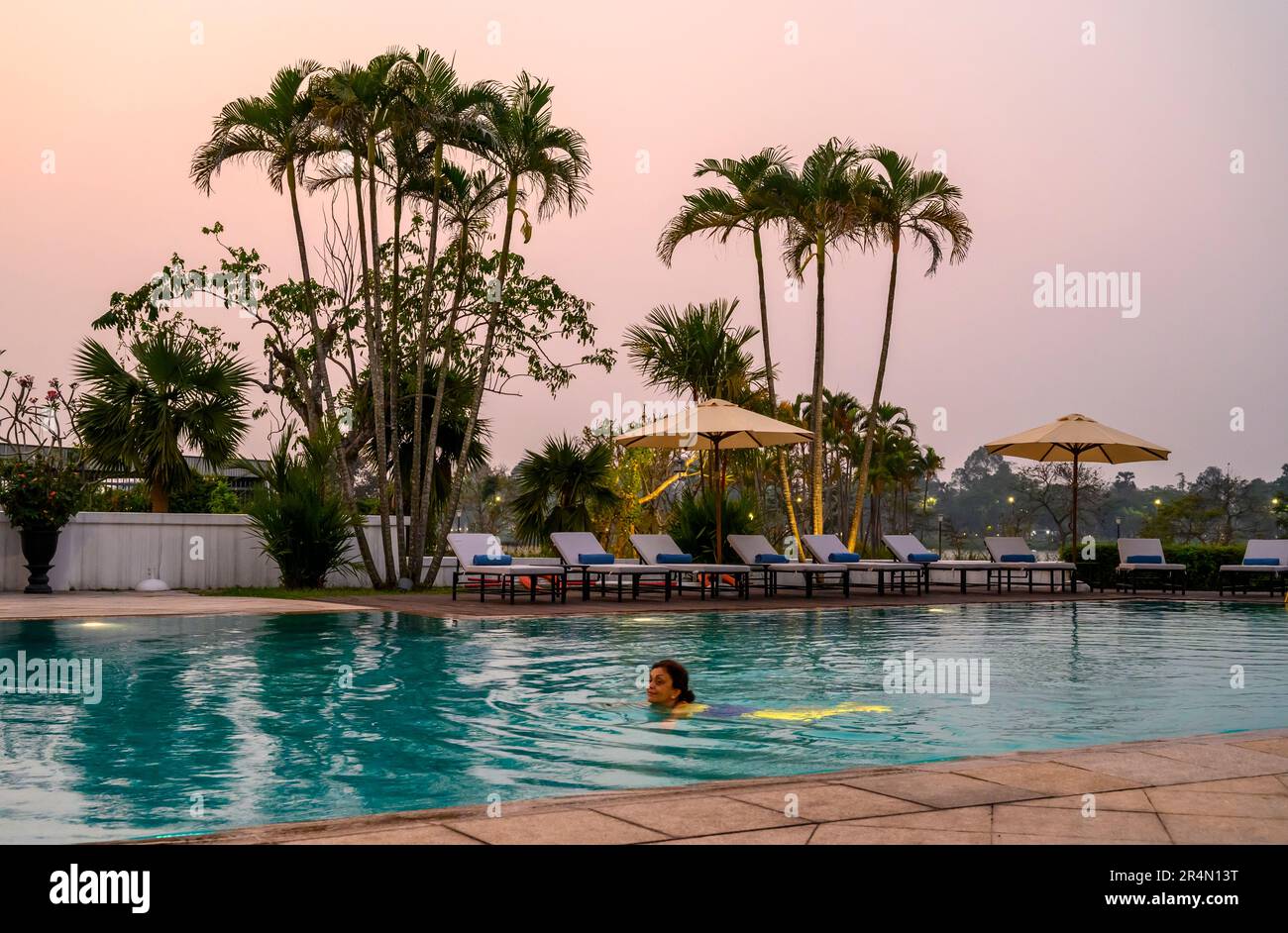 La piscine à la tombée de la nuit à l'hôtel Azerai la Residence à Hue, Vietnam. Banque D'Images