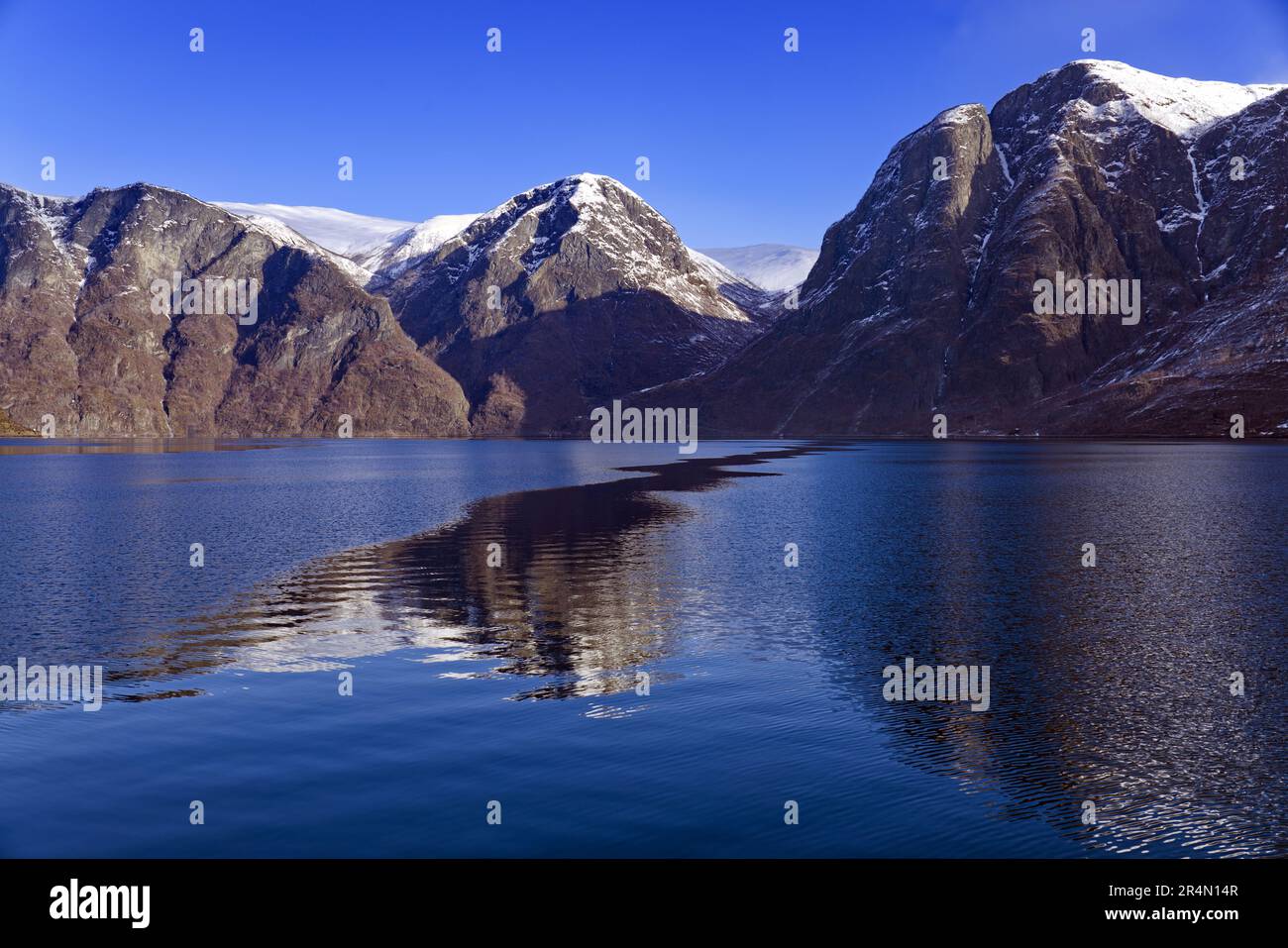 Croisière en ferry de Flam à Gudvangen en Norvège - Aurlandsfjord entouré de montagnes enneigées reflétées dans les eaux calmes du fjord Banque D'Images