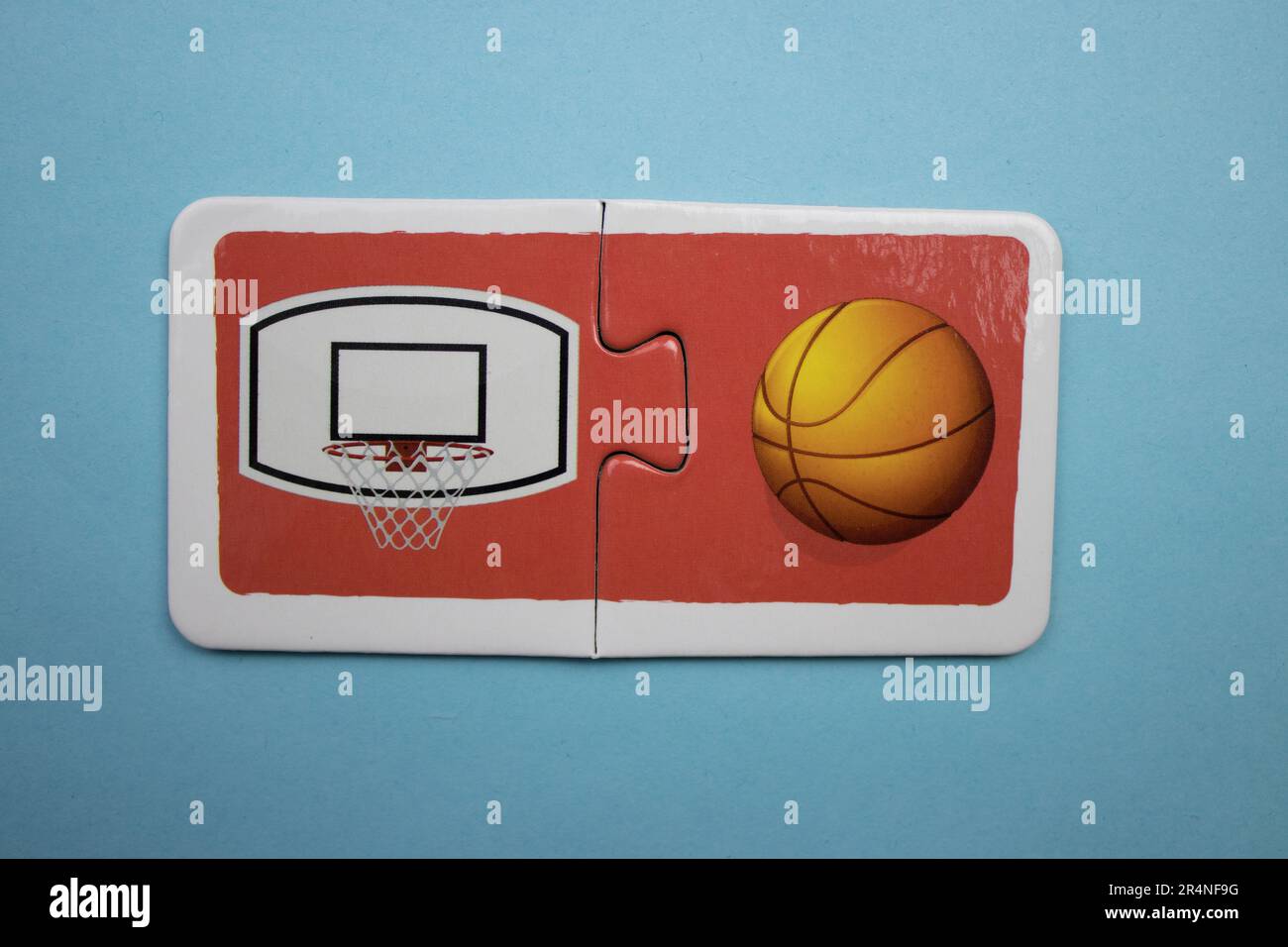 Casse-têtes d'images superposés sur fond bleu. Basket-ball et panier de basket-ball. Banque D'Images