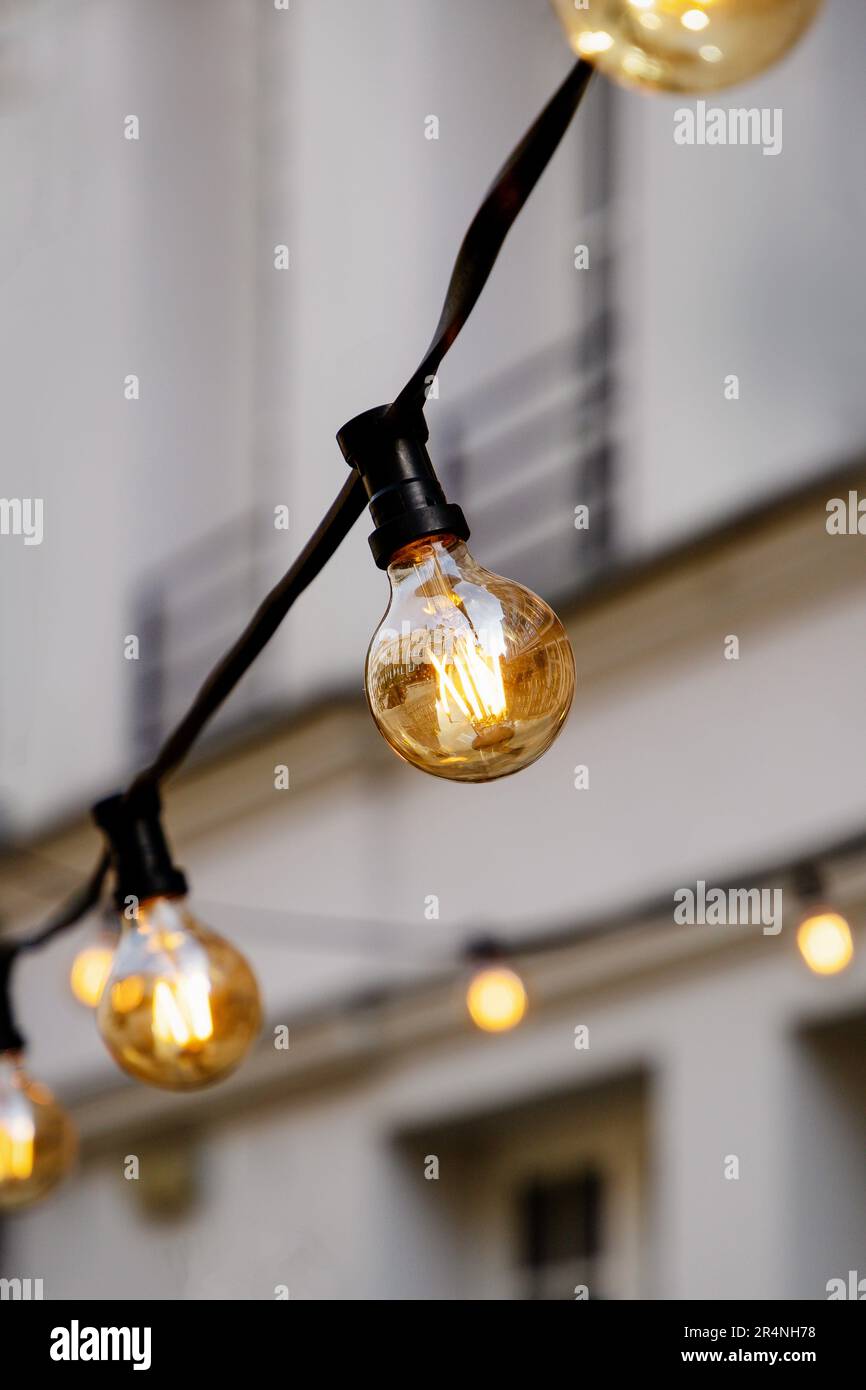 Ampoules lumineuses sur un fil sur un fond mural Banque D'Images