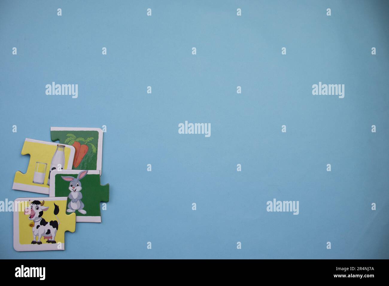 Des puzzles d'information, photographiés d'en haut, placés sur le bord de l'arrière-plan bleu. Vache et lapin. Banque D'Images