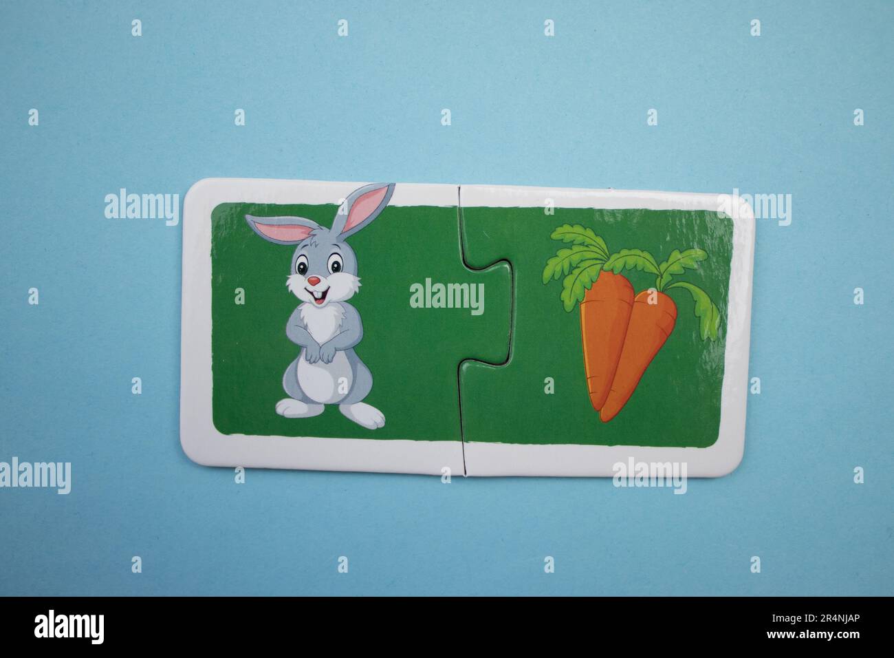 Des puzzles d'information, photographiés d'en haut, placés sur un fond bleu. Lapin et carotte. Banque D'Images