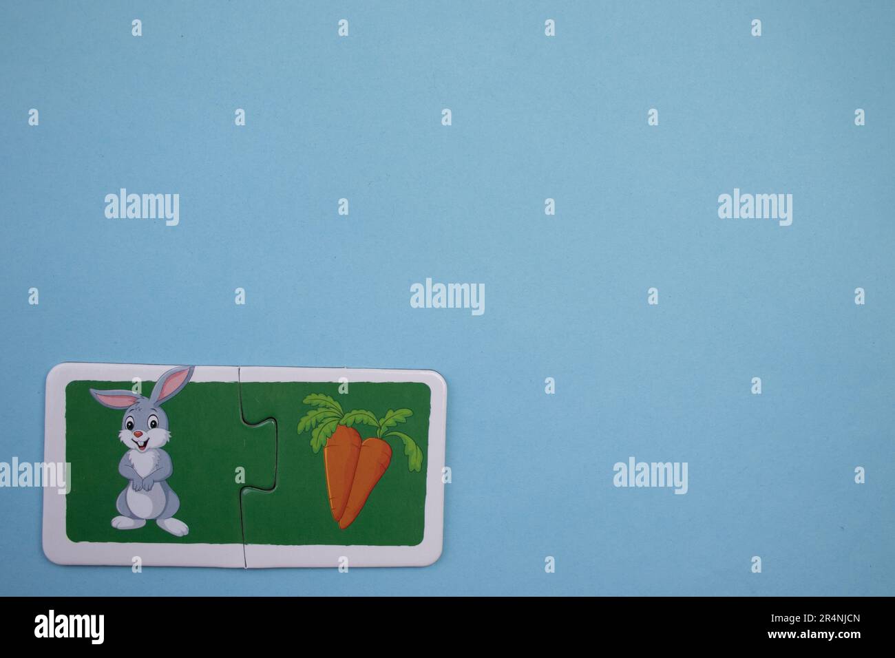 Des puzzles d'information, photographiés d'en haut, placés sur le bord de l'arrière-plan bleu. Lapin et carotte. Banque D'Images
