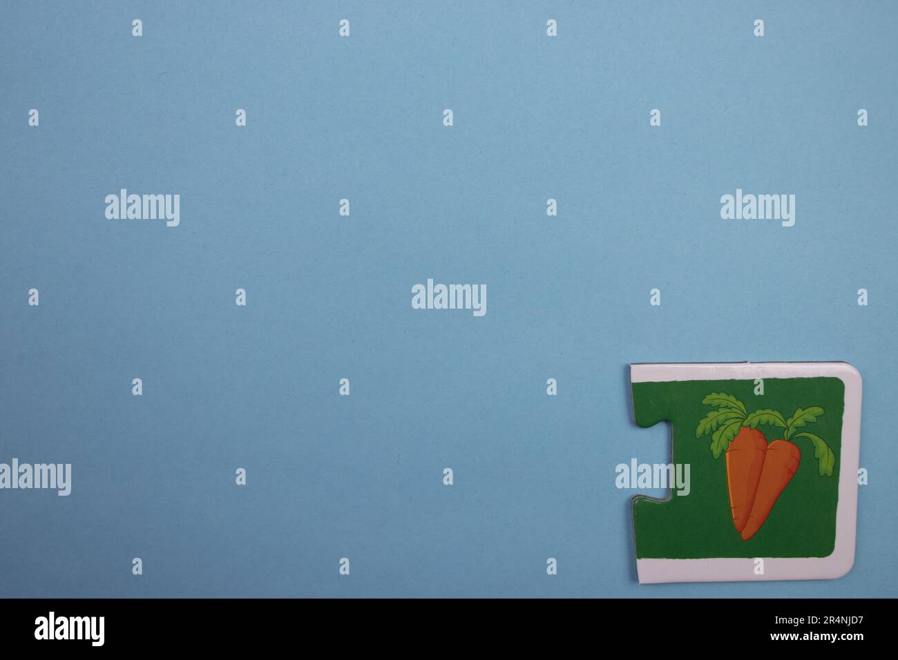 Des puzzles d'information, photographiés d'en haut, placés sur le bord de l'arrière-plan bleu. Carottes d'orange. Banque D'Images