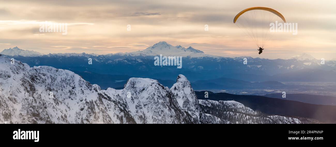 Parapente volant au-dessus du paysage des montagnes canadiennes. Composite aventure extrême. Banque D'Images