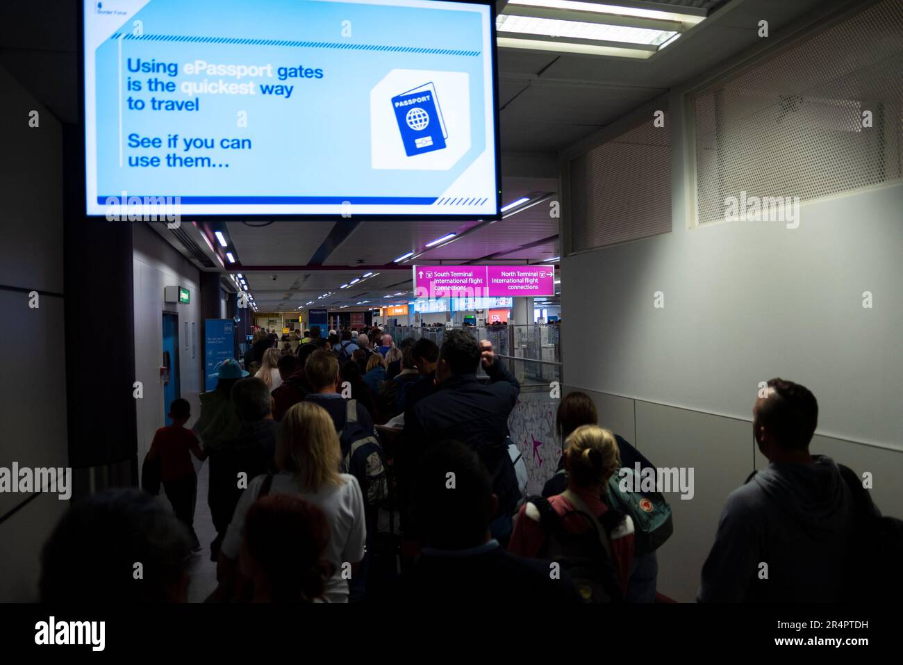 Longues files d'attente de passagers retardées par la défaillance des portes électroniques automatiques à l'aéroport de Londres Gatwick, Royaume-Uni. Signe favorisant la vitesse d'utilisation d'un ePassport Banque D'Images