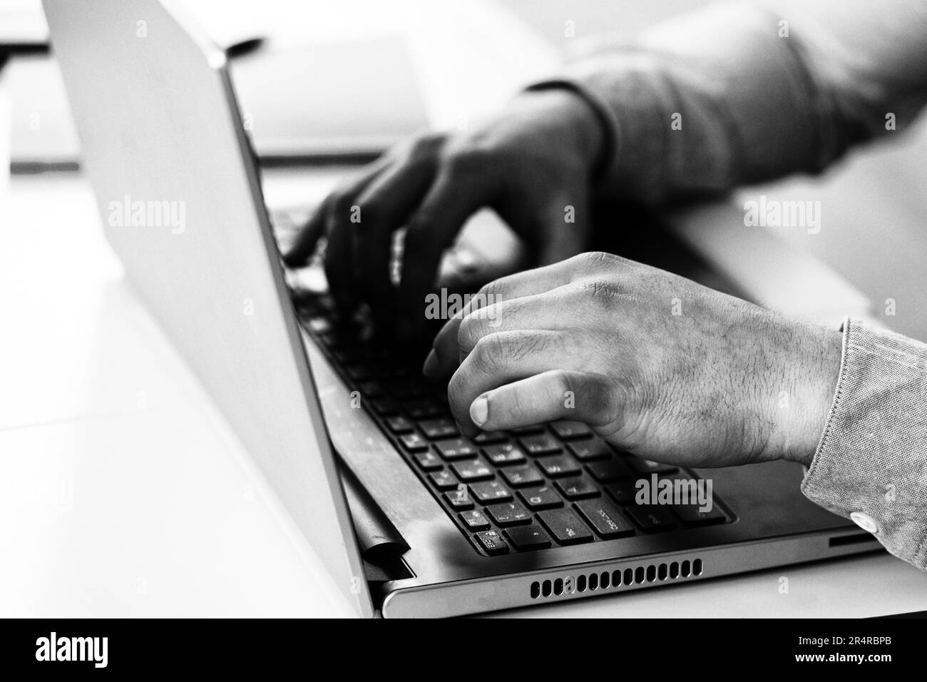 Gros plan image de Homme dactylographiant les mains sur le clavier de l'ordinateur portable et surfant sur Internet sur une table de bureau Banque D'Images